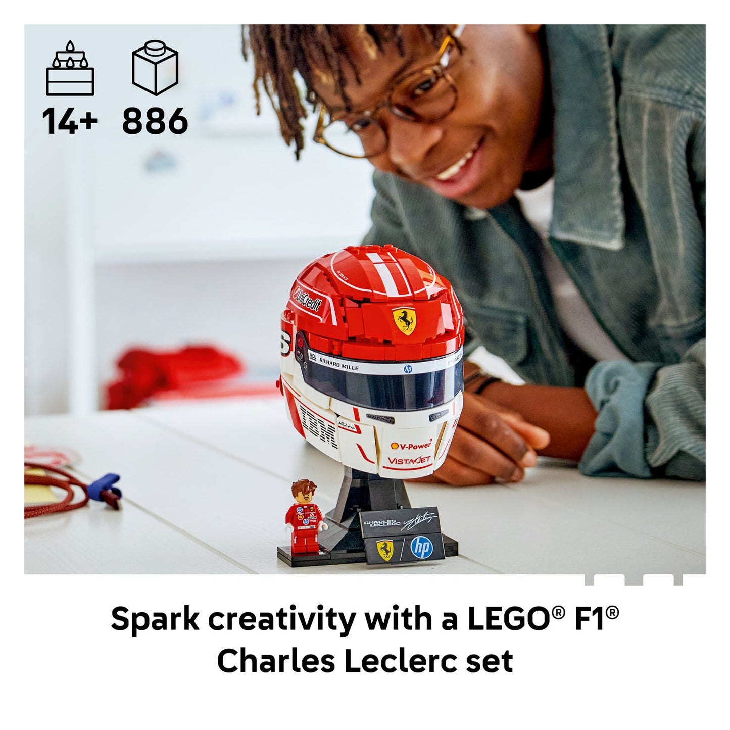 Person interacting with a LEGO F1 Charles Leclerc set on a table.