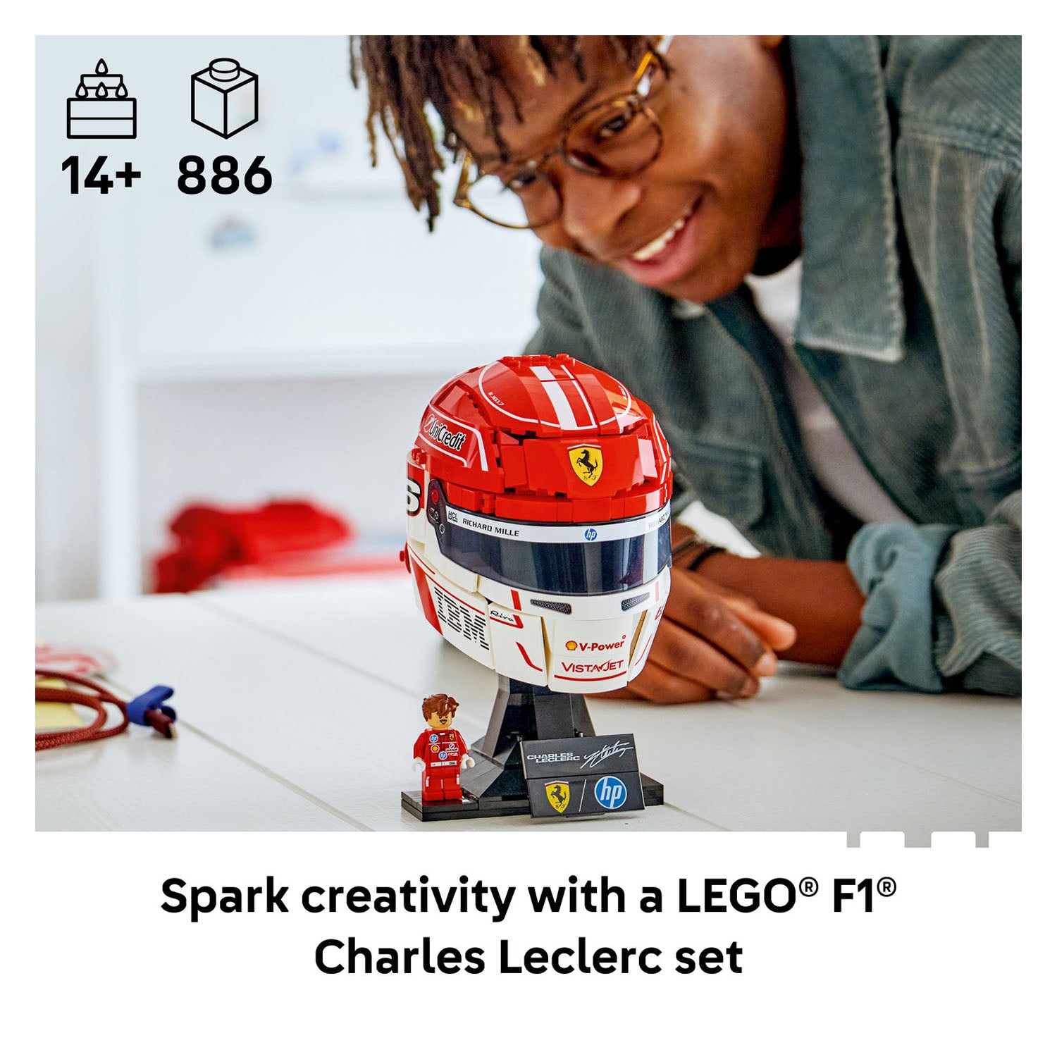 Person interacting with a LEGO F1 Charles Leclerc set on a table.