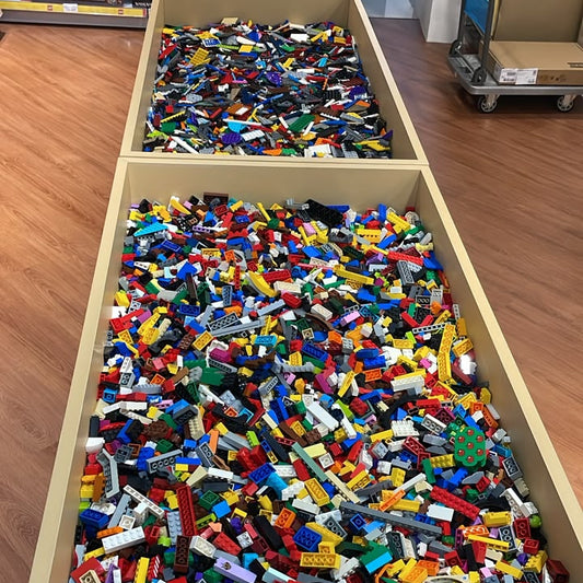 Large collection of colorful building blocks in a storage unit.